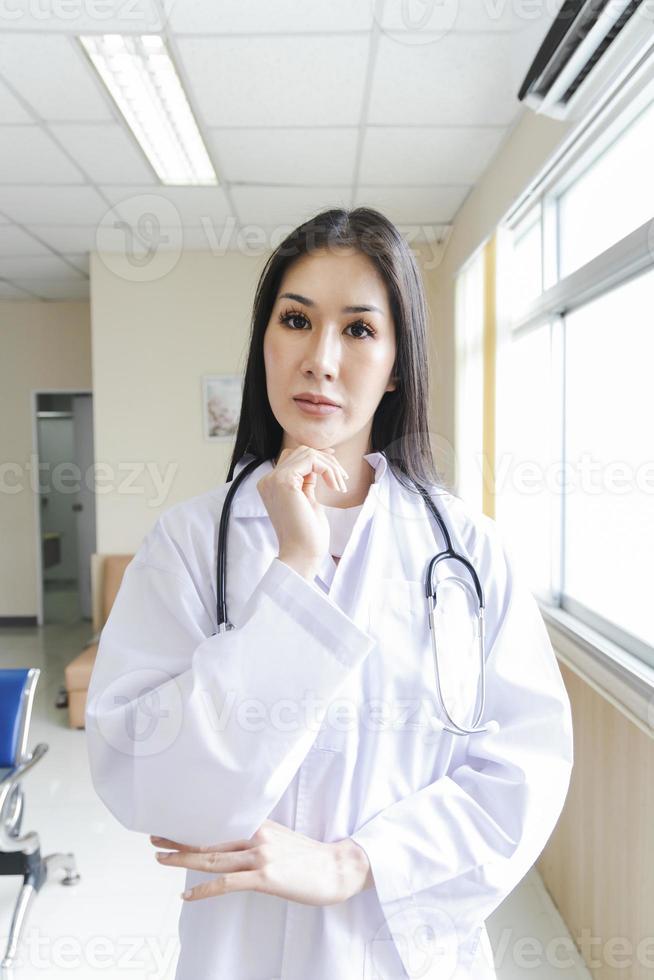 Retrato de una doctora inteligente con un estetoscopio de pie en la recepción del hospital. foto