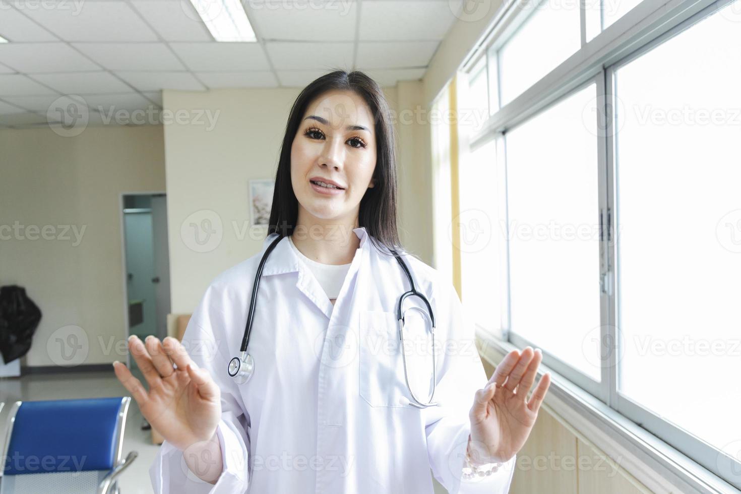 Retrato de una doctora inteligente con un estetoscopio de pie en la recepción del hospital. foto