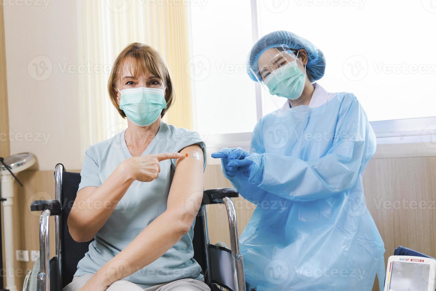 Paciente anciana recibiendo la vacuna covid-19 o coronavirus en silla de ruedas foto