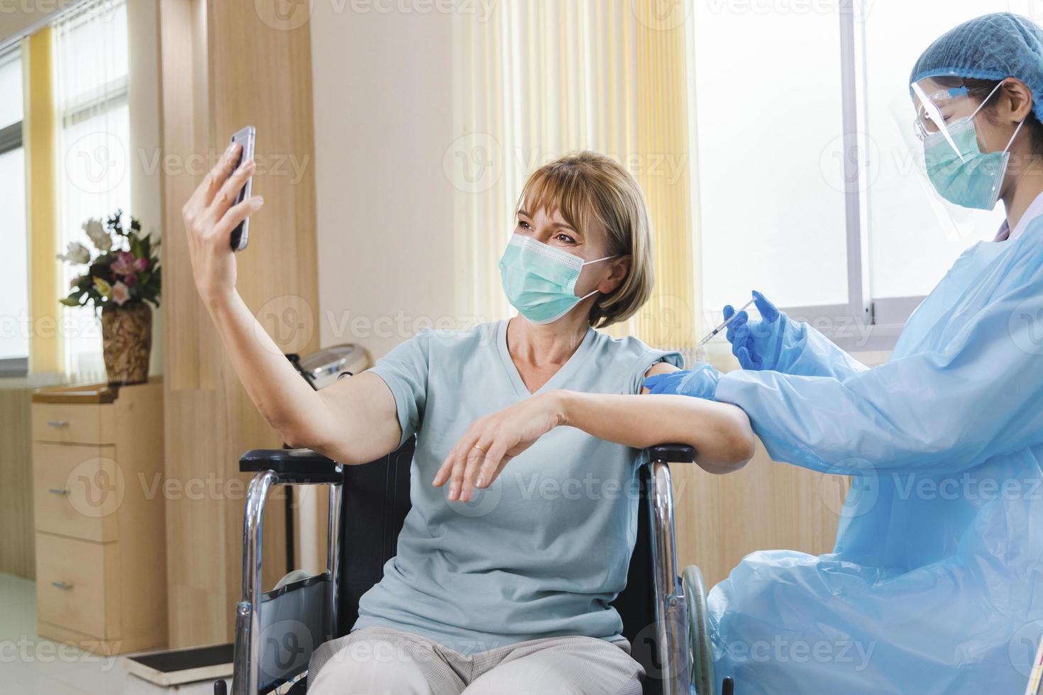 elderly woman patient getting covid-19 or coronavirus vaccine in a wheelchair photo