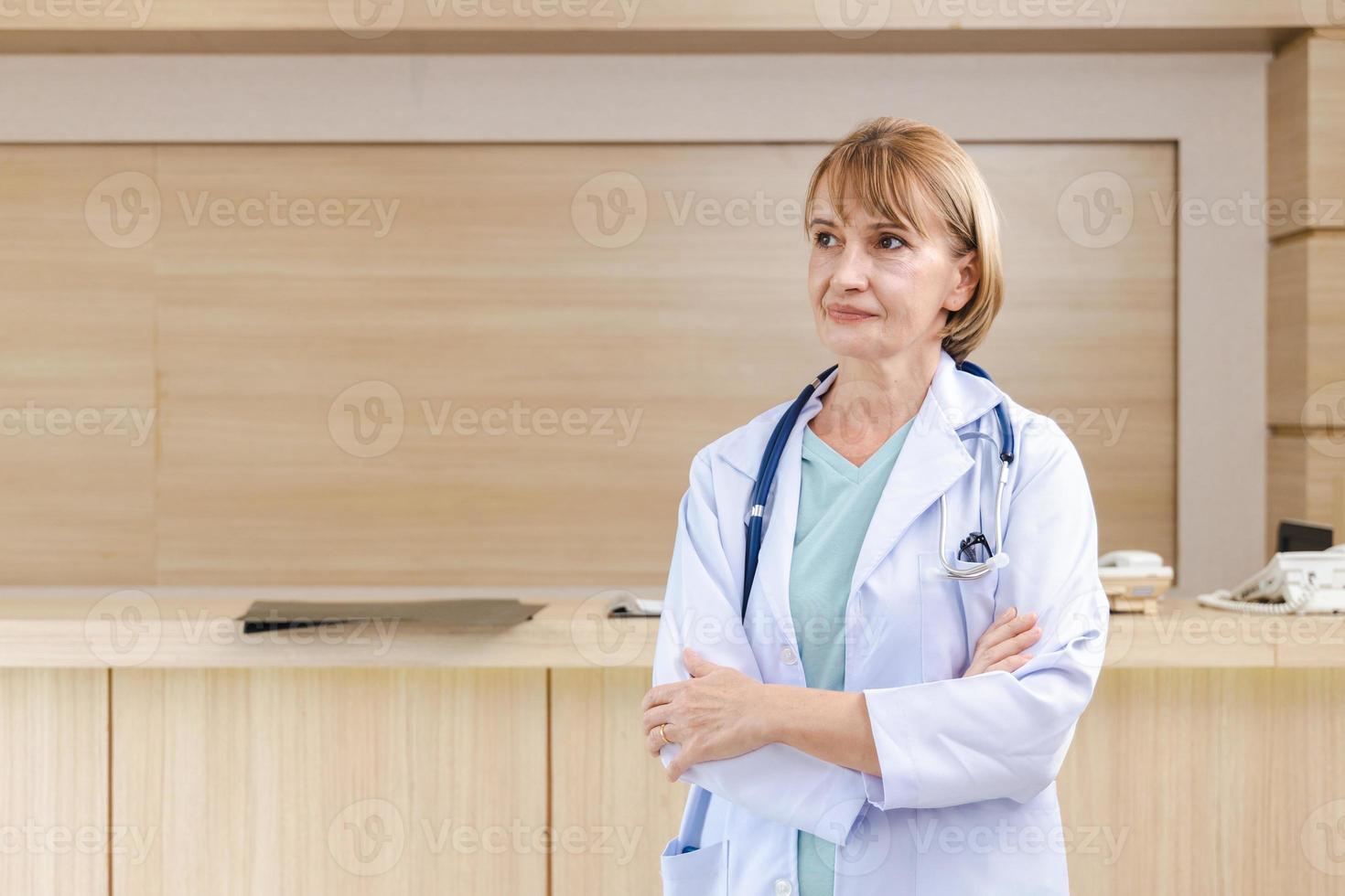 Retrato de una doctora inteligente con un estetoscopio de pie en la recepción del hospital. foto