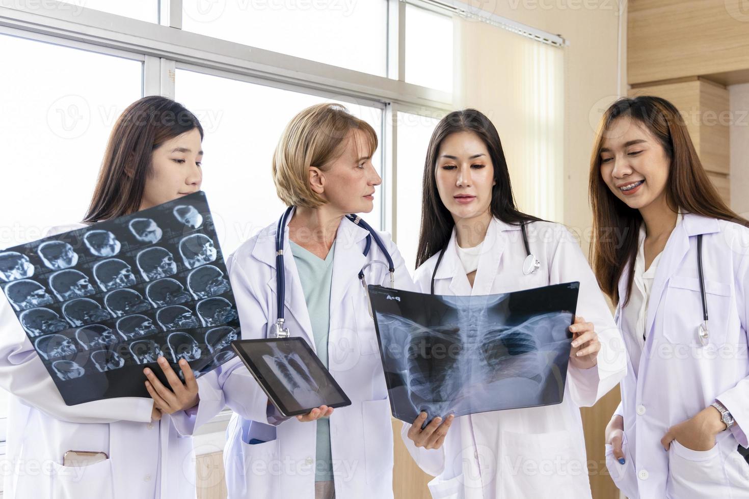 Senior doctor woman teaching doctor student woman. How to analyze the X-ray film. Radiology department photo