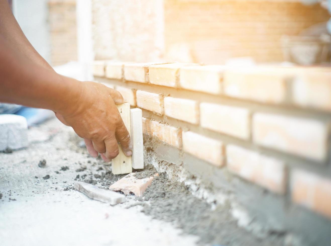 Close up of industrial bricklayer installing bricks on construction site photo