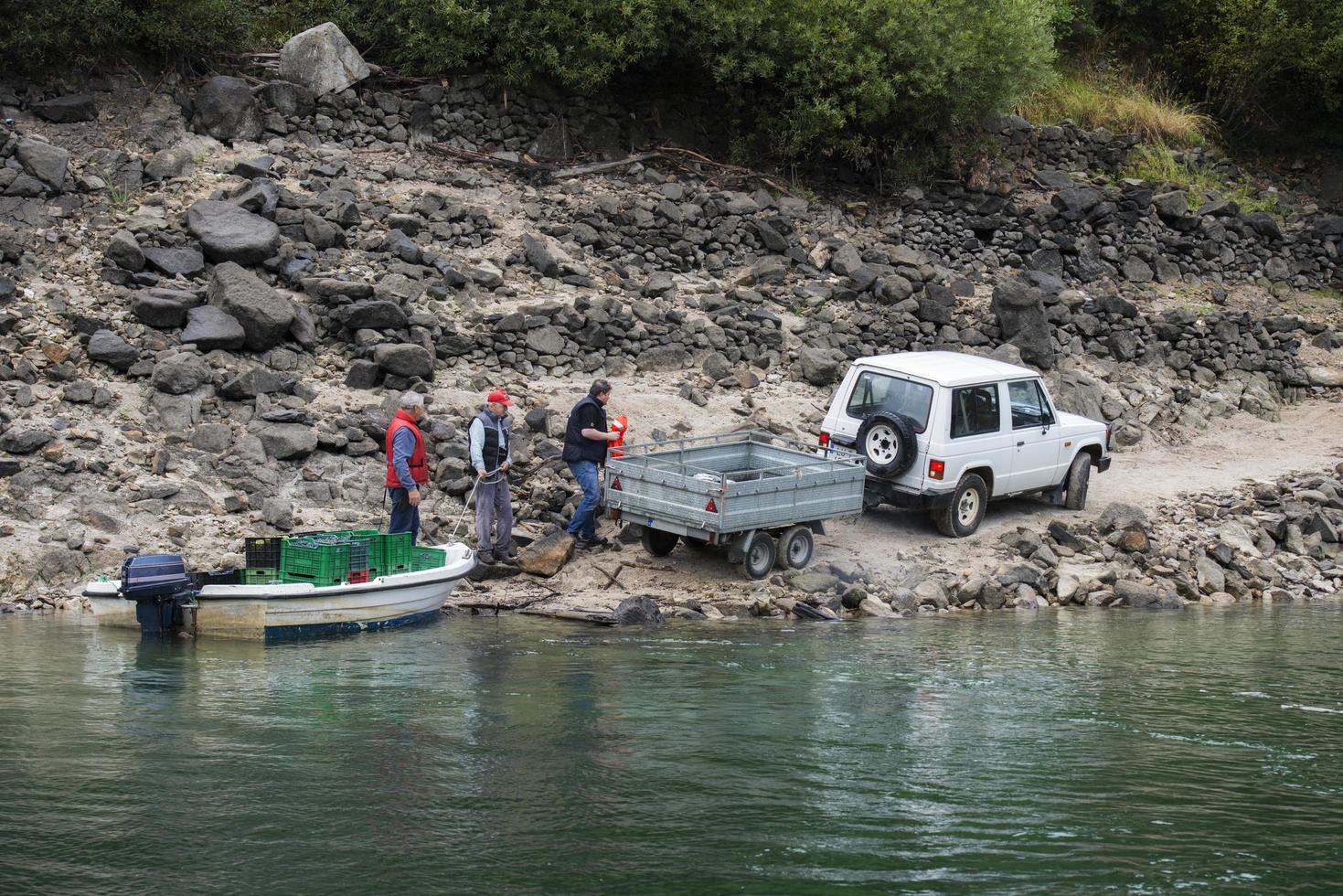 lugo, galicia, españa, 2021. Hombres llevando uvas a tierra después de transportarlas en bote río abajo desde el viñedo foto