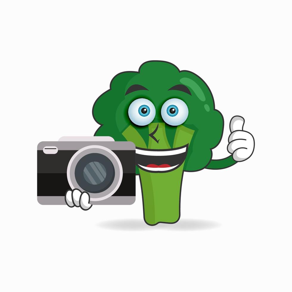 Broccoli mascot character holding camera. vector illustration