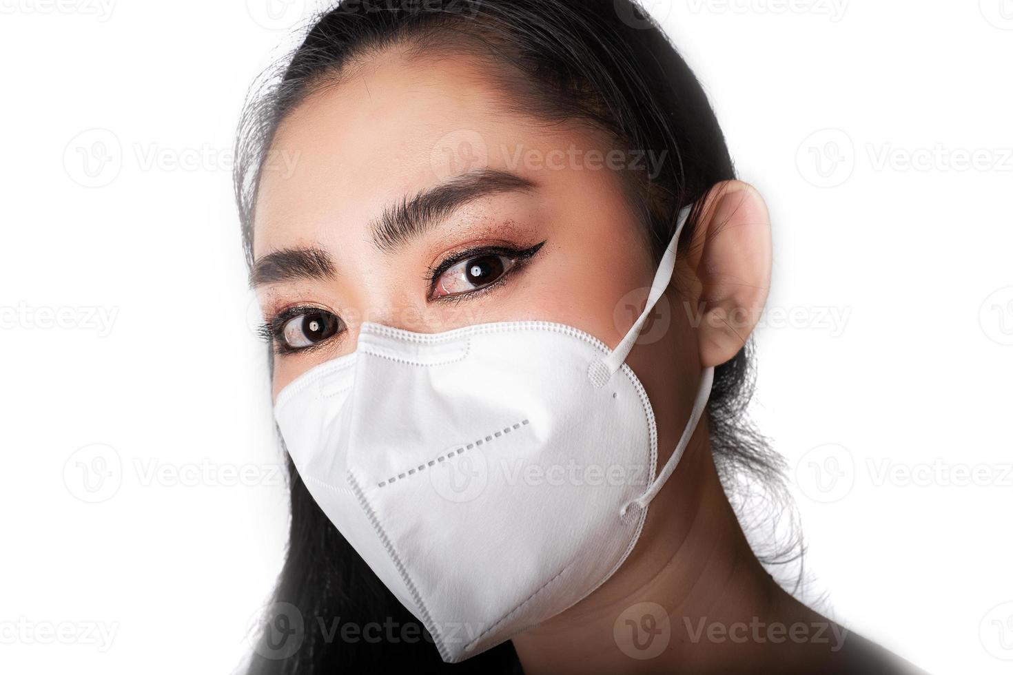 Cerca de una mujer que se pone un respirador n95 máscara para protegerse de enfermedades respiratorias transmitidas por el aire como la gripe covid-19 coronavirus ébola pm2.5 polvo y smog foto