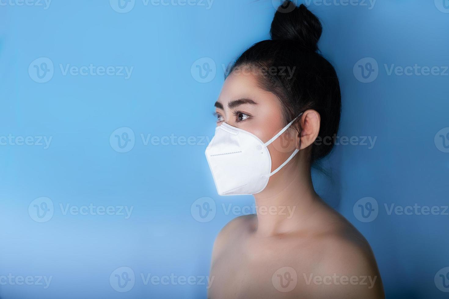 Cerca de una mujer que se pone un respirador n95 máscara para protegerse de enfermedades respiratorias transmitidas por el aire como la gripe covid-19 coronavirus ébola pm2.5 polvo y smog foto