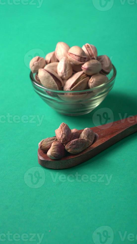 Pistachios or Pista nuts decorated with green leaves. plain background, top view.Flat lay. photo