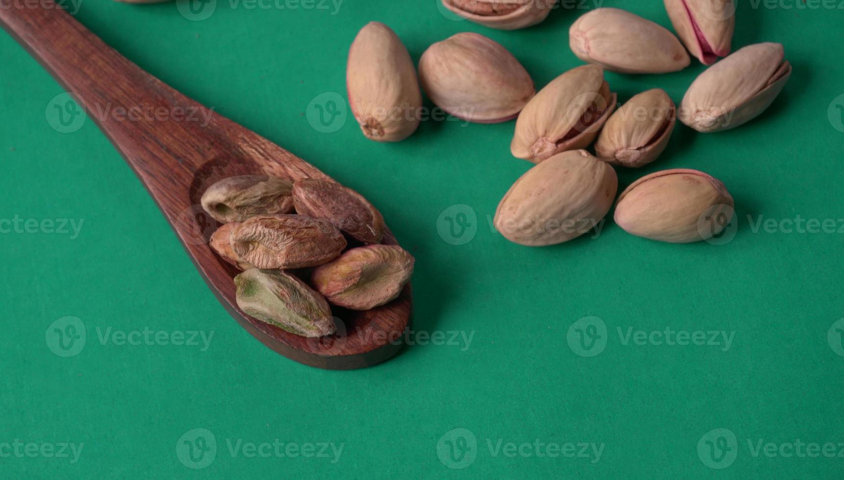 Pistachios or Pista nuts decorated with green leaves. plain background, top view.Flat lay. photo