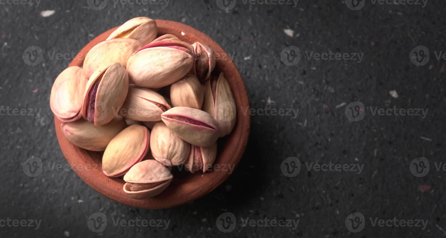 Pistachios or Pista nuts decorated with green leaves. plain background, top view.Flat lay. photo