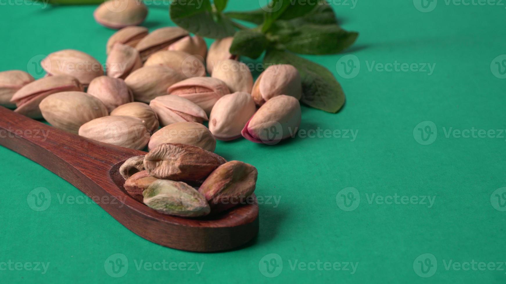 Pistachios or Pista nuts decorated with green leaves. plain background, top view.Flat lay. photo