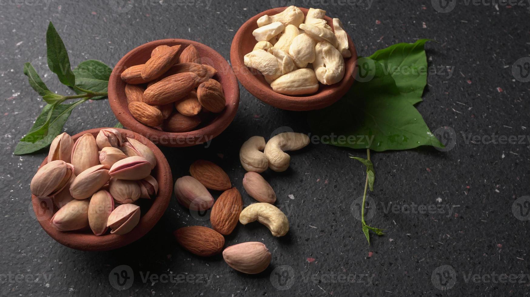 Pistachios or Pista nuts decorated with green leaves. plain background, top view.Flat lay. photo