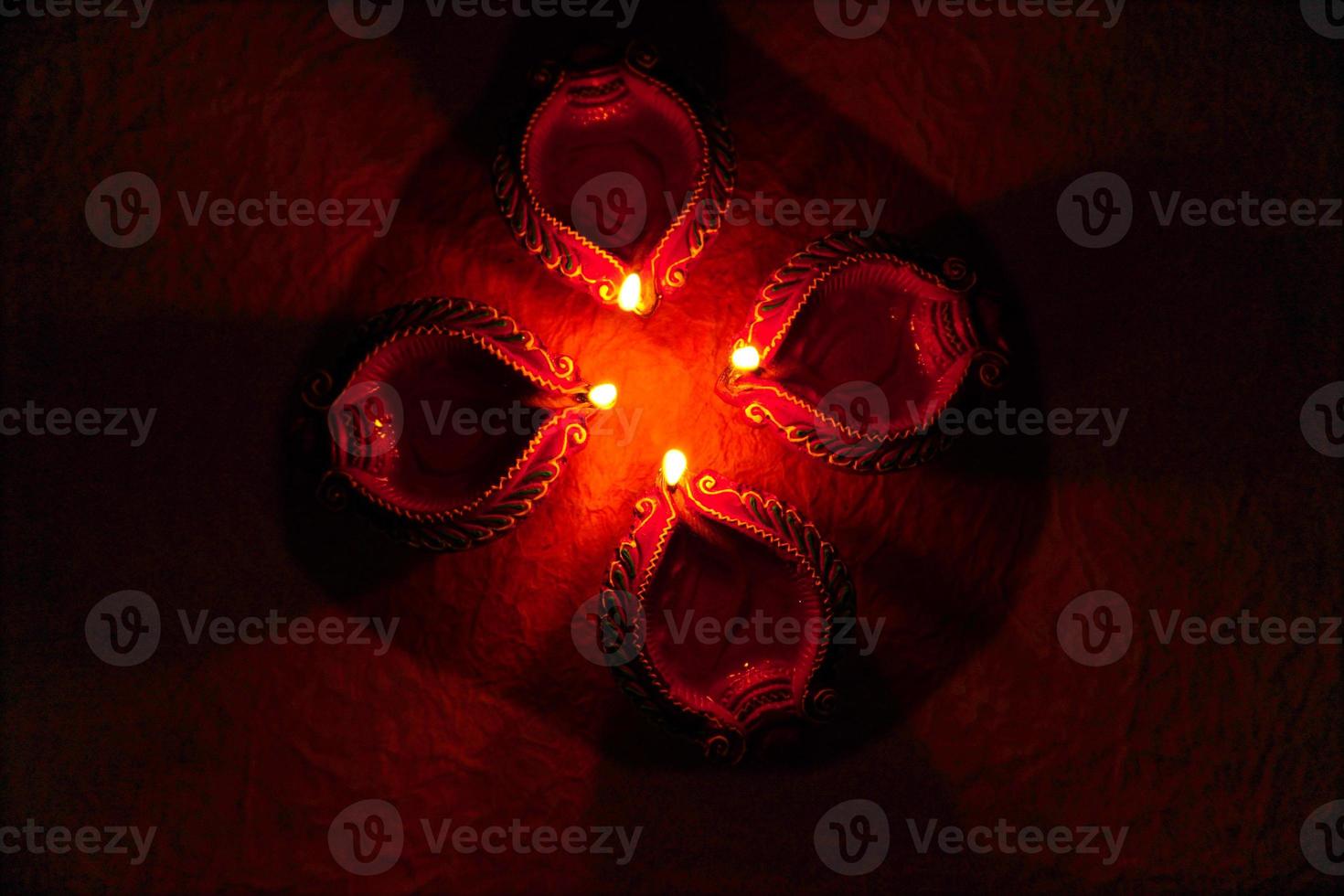 Happy Diwali - Diya lamps lit during Diwali celebration. Colourful and decorated lantern are lit in night on this occassion with flower rangoli, sweets and gifts. photo