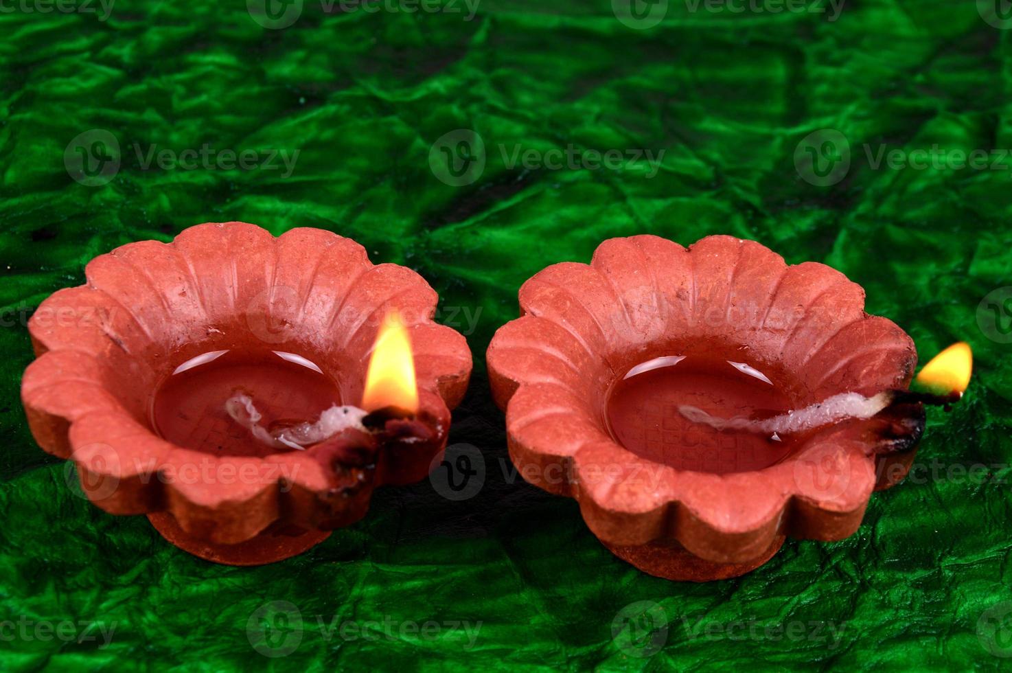 Happy Diwali - Diya lamps lit during Diwali celebration. Colourful and decorated lantern are lit in night on this occasion with flower Rangoli, sweets and gifts. photo