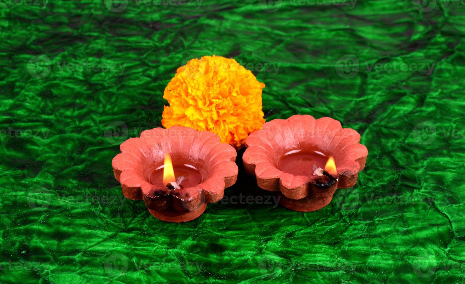 Happy Diwali - Diya lamps lit during Diwali celebration. Colourful and decorated lantern are lit in night on this occasion with flower Rangoli, sweets and gifts. photo