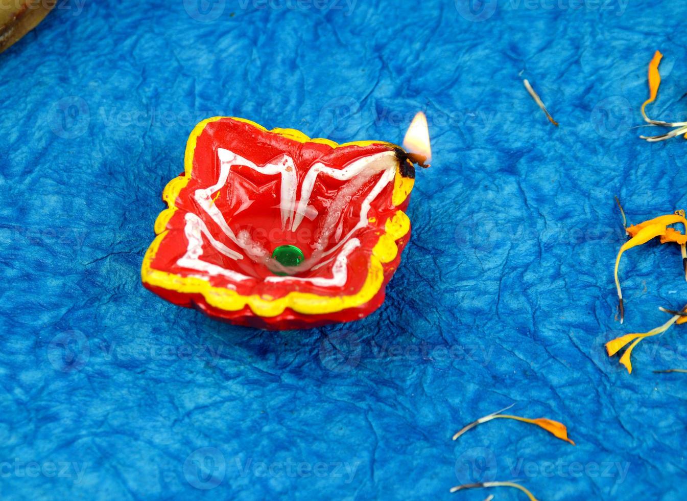 Happy Diwali - Diya lamps lit during Diwali celebration. Colourful and decorated lantern are lit in night on this occasion with flower Rangoli, sweets and gifts. photo