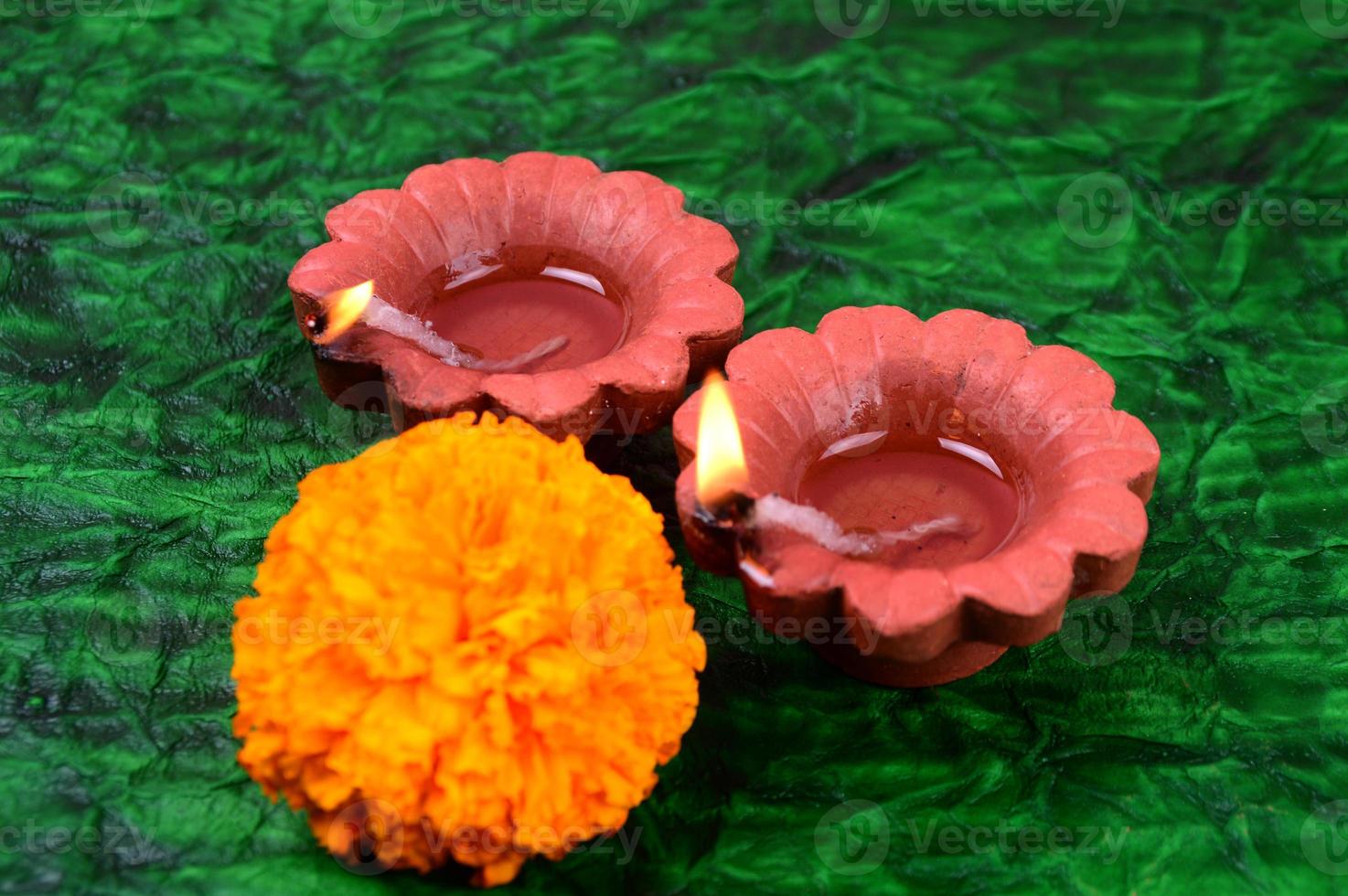 Happy Diwali - Diya lamps lit during Diwali celebration. Colourful and decorated lantern are lit in night on this occasion with flower Rangoli, sweets and gifts. photo