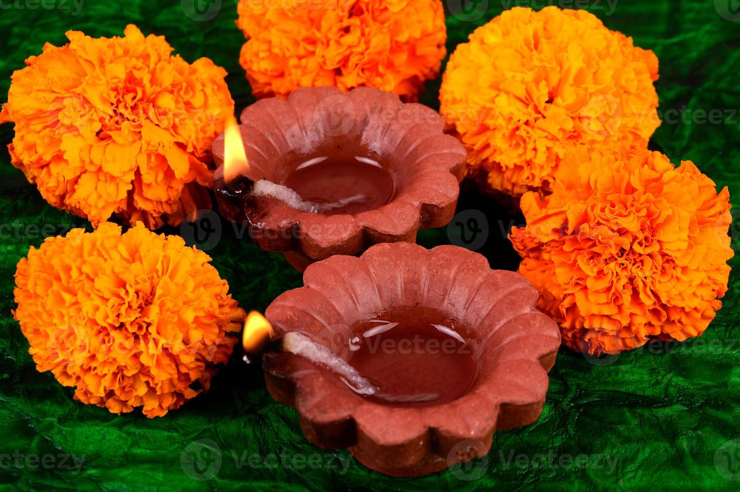 Happy Diwali - Diya lamps lit during Diwali celebration. Colourful and decorated lantern are lit in night on this occasion with flower Rangoli, sweets and gifts. photo