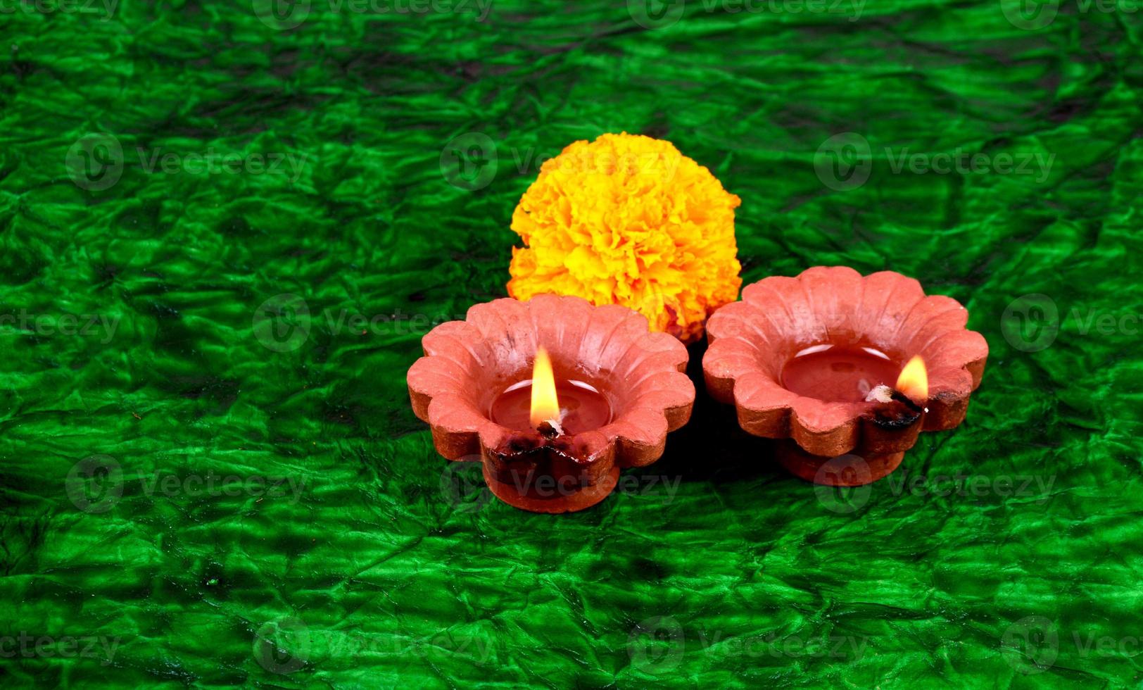 Happy Diwali - Diya lamps lit during Diwali celebration. Colourful and decorated lantern are lit in night on this occasion with flower Rangoli, sweets and gifts. photo