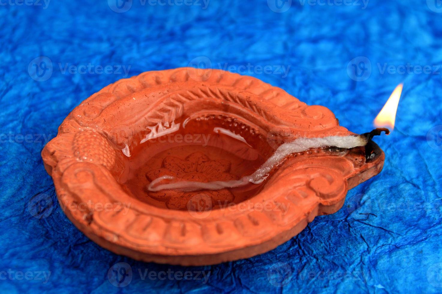 Happy Diwali - Diya lamps lit during Diwali celebration. Colourful and decorated lantern are lit in night on this occasion with flower Rangoli, sweets and gifts. photo