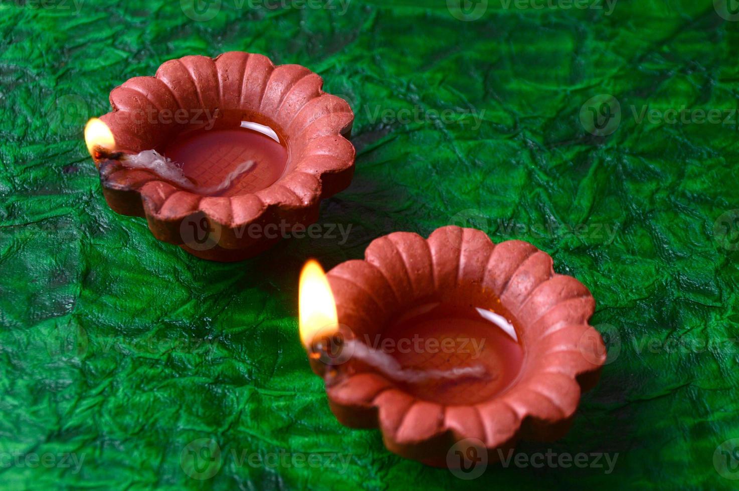 Happy Diwali - Diya lamps lit during Diwali celebration. Colourful and decorated lantern are lit in night on this occasion with flower Rangoli, sweets and gifts. photo