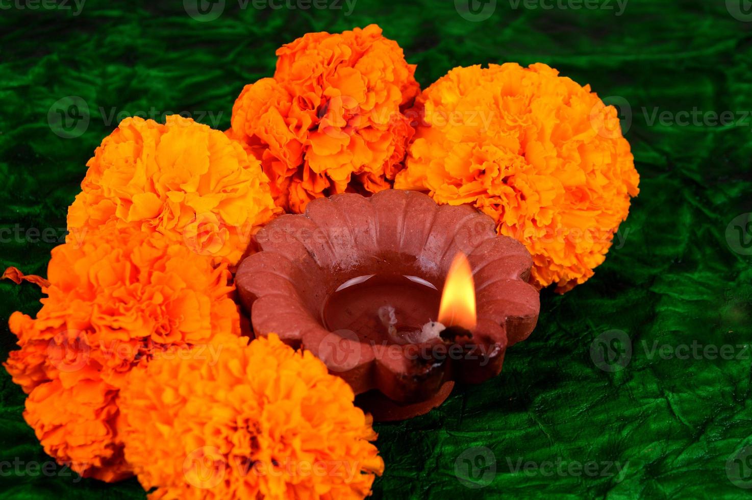 Happy Diwali - Diya lamps lit during Diwali celebration. Colourful and decorated lantern are lit in night on this occasion with flower Rangoli, sweets and gifts. photo