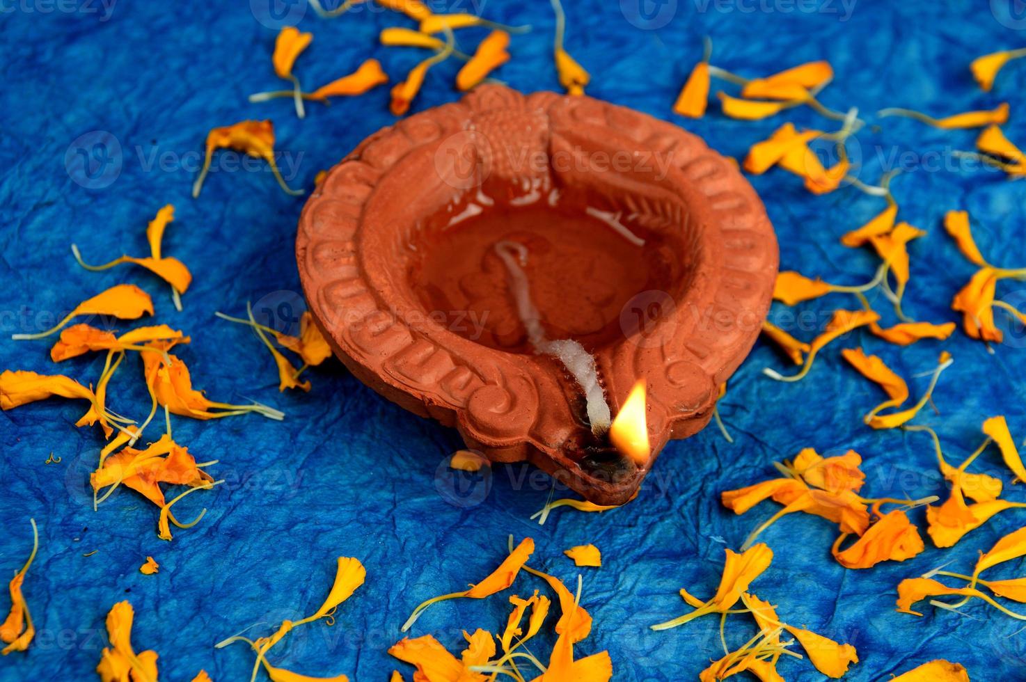 Happy Diwali - Diya lamps lit during Diwali celebration. Colourful and decorated lantern are lit in night on this occasion with flower Rangoli, sweets and gifts. photo