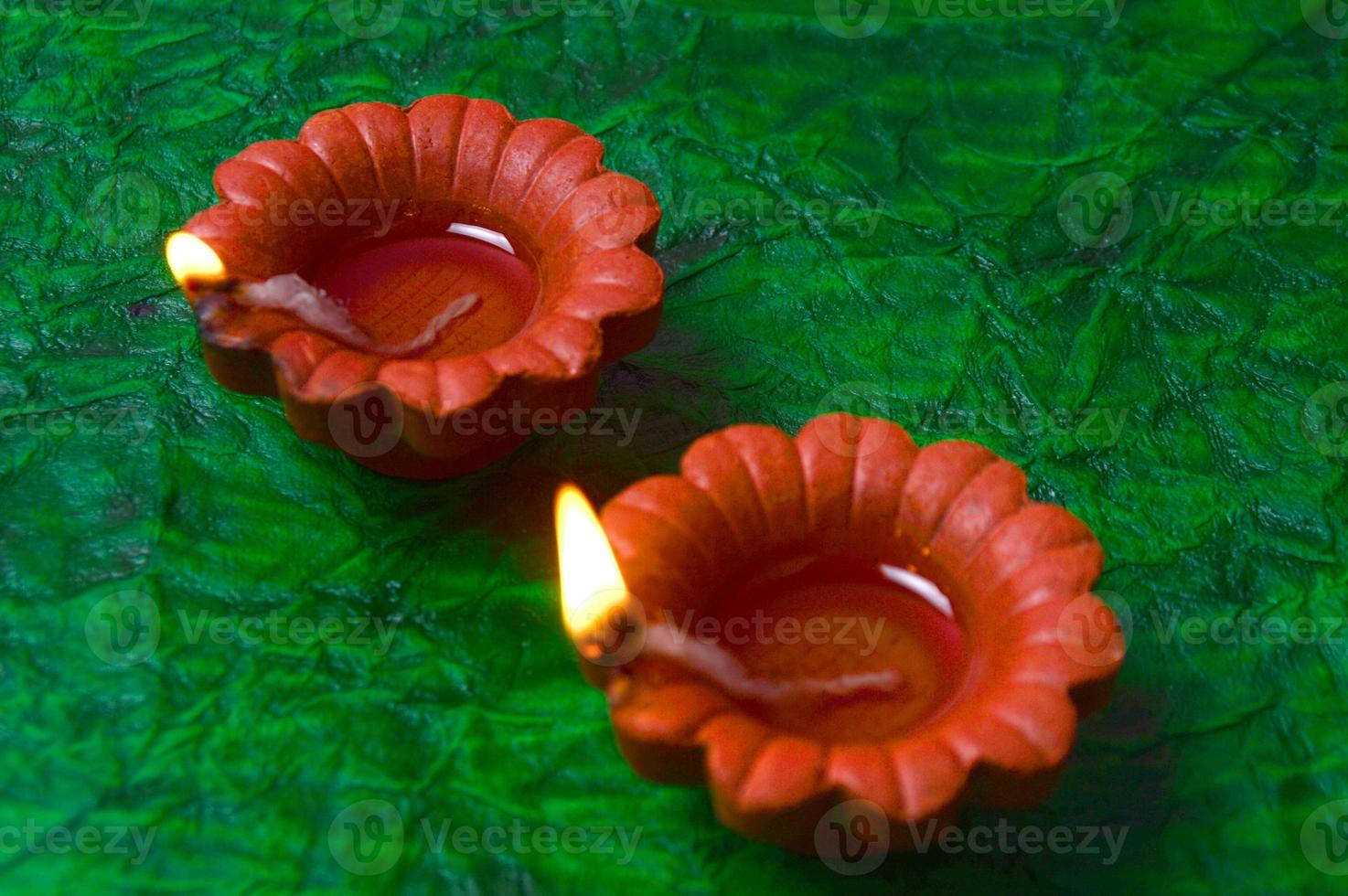 Happy Diwali - Diya lamps lit during Diwali celebration. Colourful and decorated lantern are lit in night on this occasion with flower Rangoli, sweets and gifts. photo