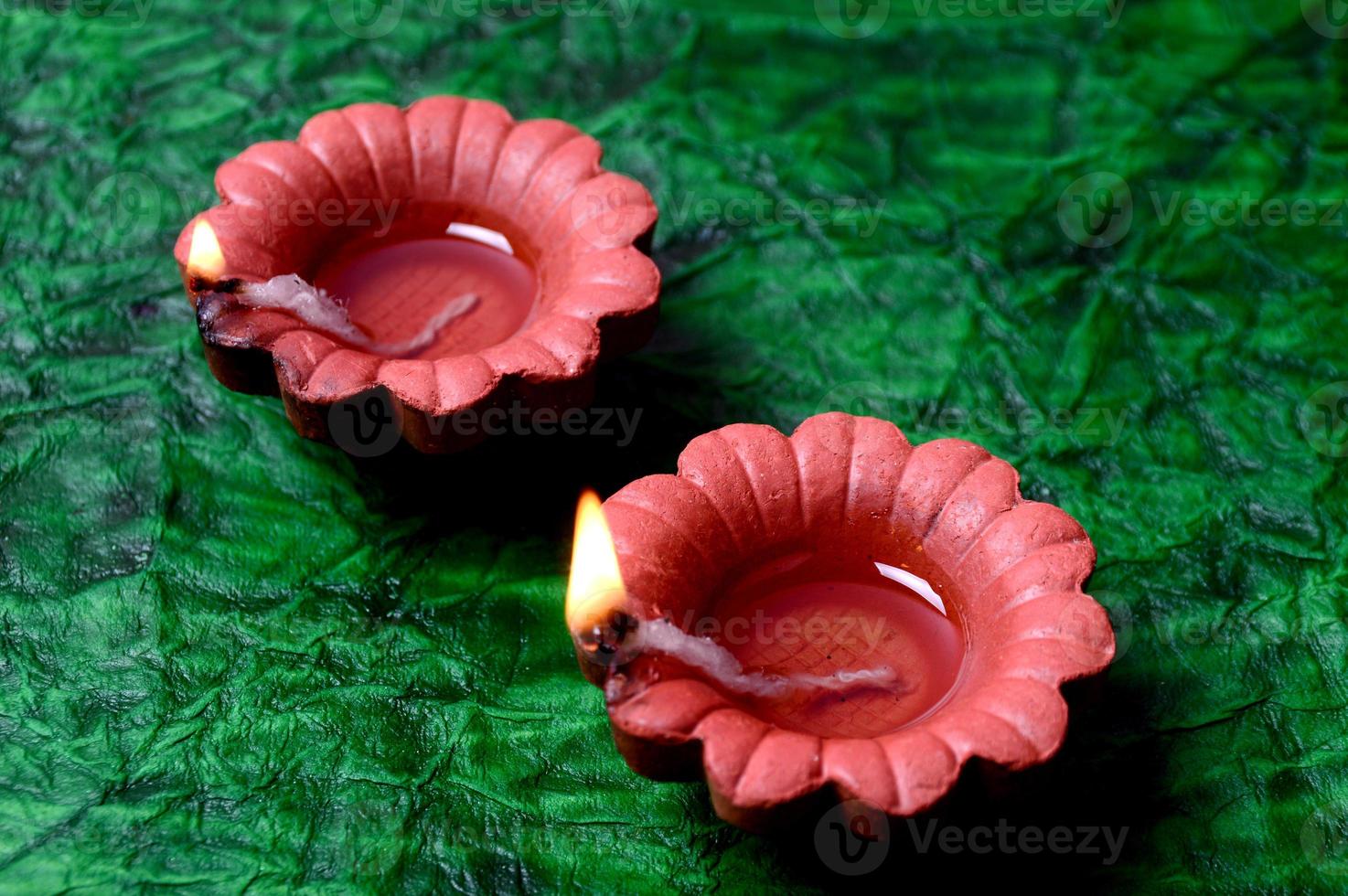 Happy Diwali - Diya lamps lit during Diwali celebration. Colourful and decorated lantern are lit in night on this occasion with flower Rangoli, sweets and gifts. photo
