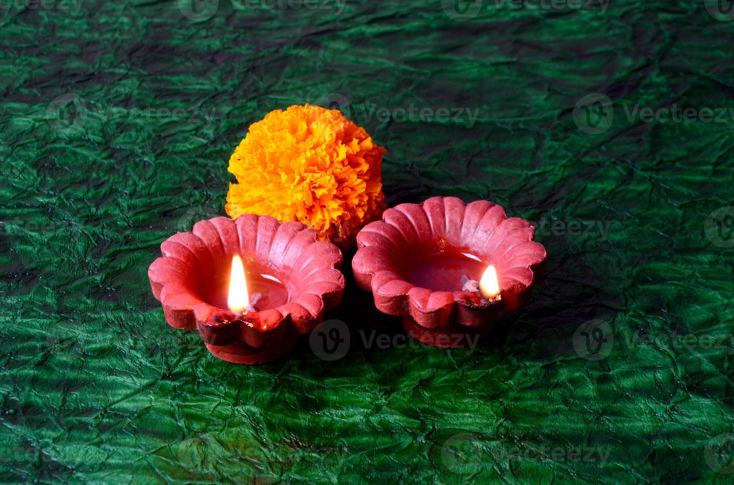 Happy Diwali - Diya lamps lit during Diwali celebration. Colourful and decorated lantern are lit in night on this occasion with flower Rangoli, sweets and gifts. photo