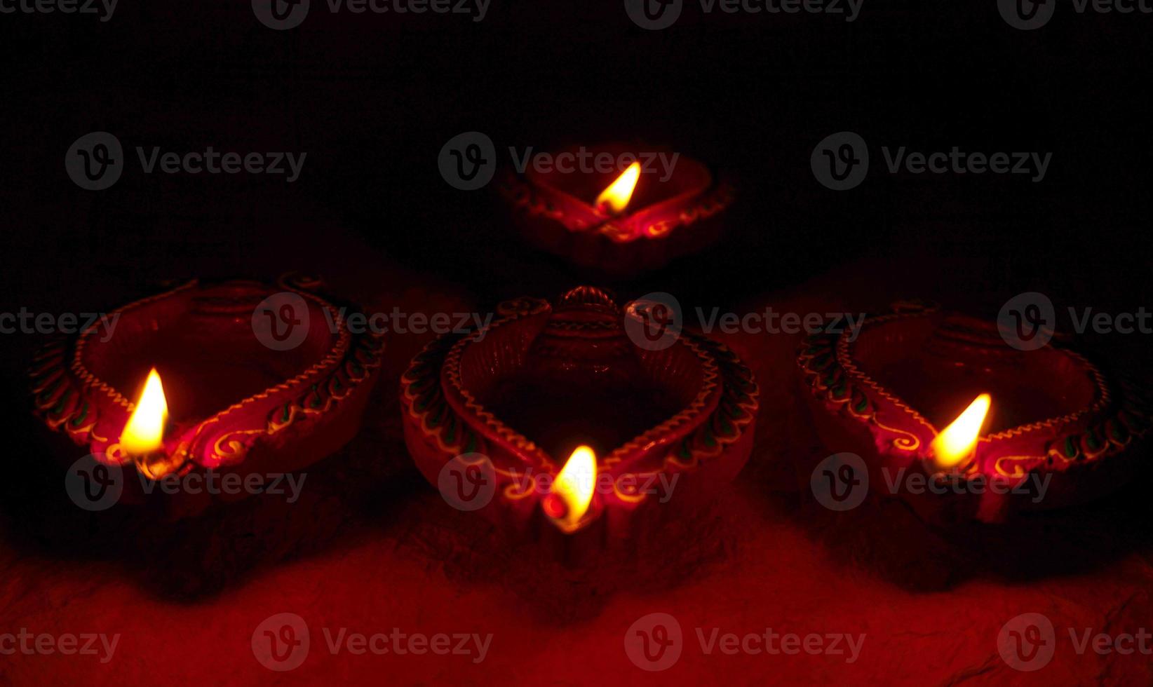 Happy Diwali - Diya lamps lit during Diwali celebration. Colourful and decorated lantern are lit in night on this occassion with flower rangoli, sweets and gifts. photo
