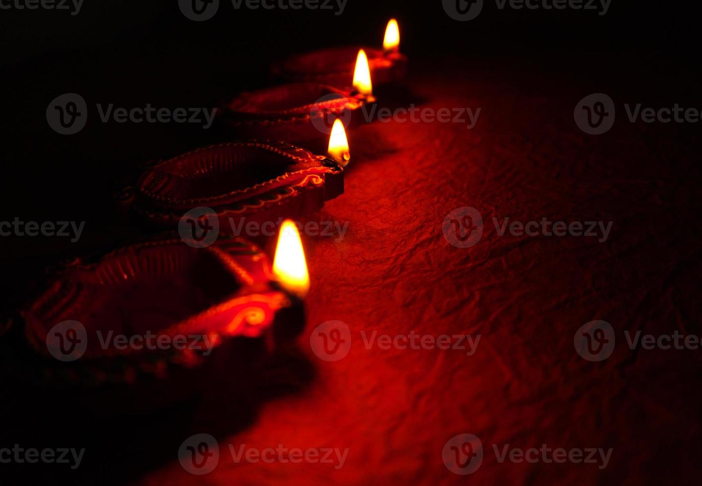Happy Diwali - Diya lamps lit during Diwali celebration. Colourful and decorated lantern are lit in night on this occassion with flower rangoli, sweets and gifts. photo