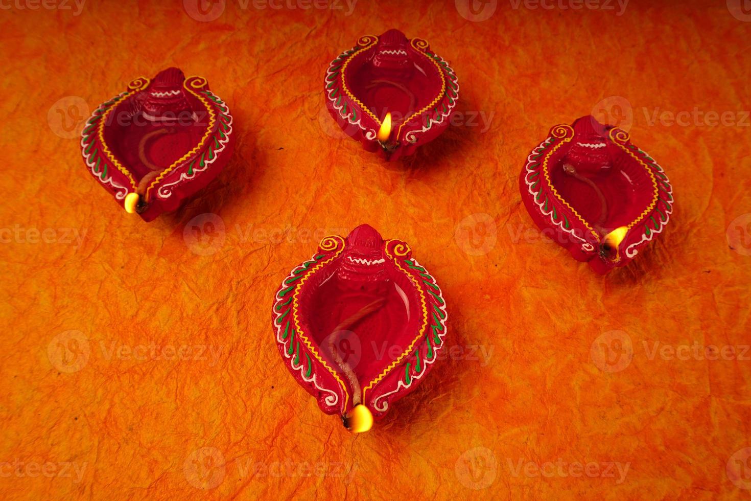 Happy Diwali - Diya lamps lit during Diwali celebration. Colourful and decorated lantern are lit in night on this occassion with flower rangoli, sweets and gifts. photo
