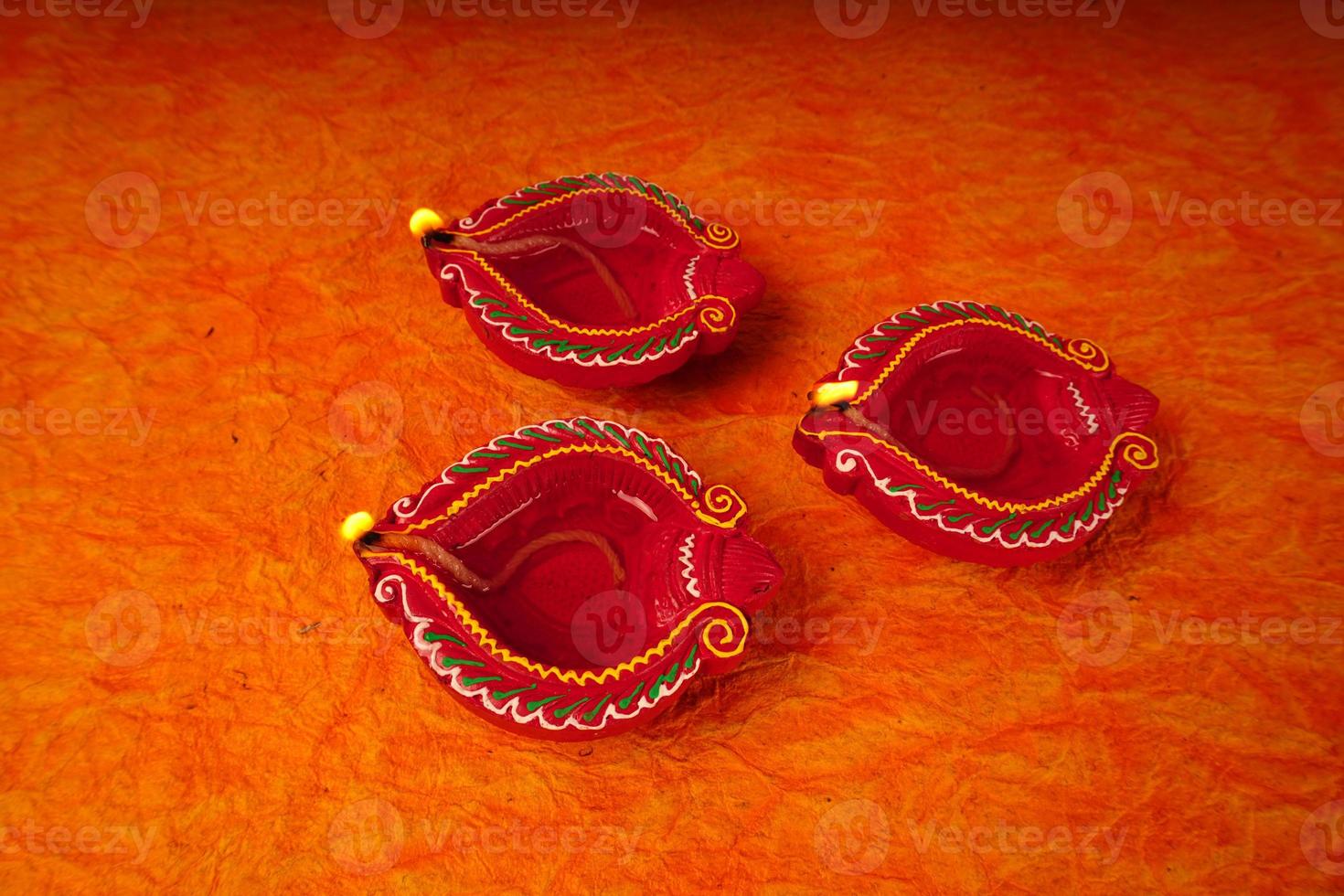 Happy Diwali - Diya lamps lit during Diwali celebration. Colourful and decorated lantern are lit in night on this occassion with flower rangoli, sweets and gifts. photo
