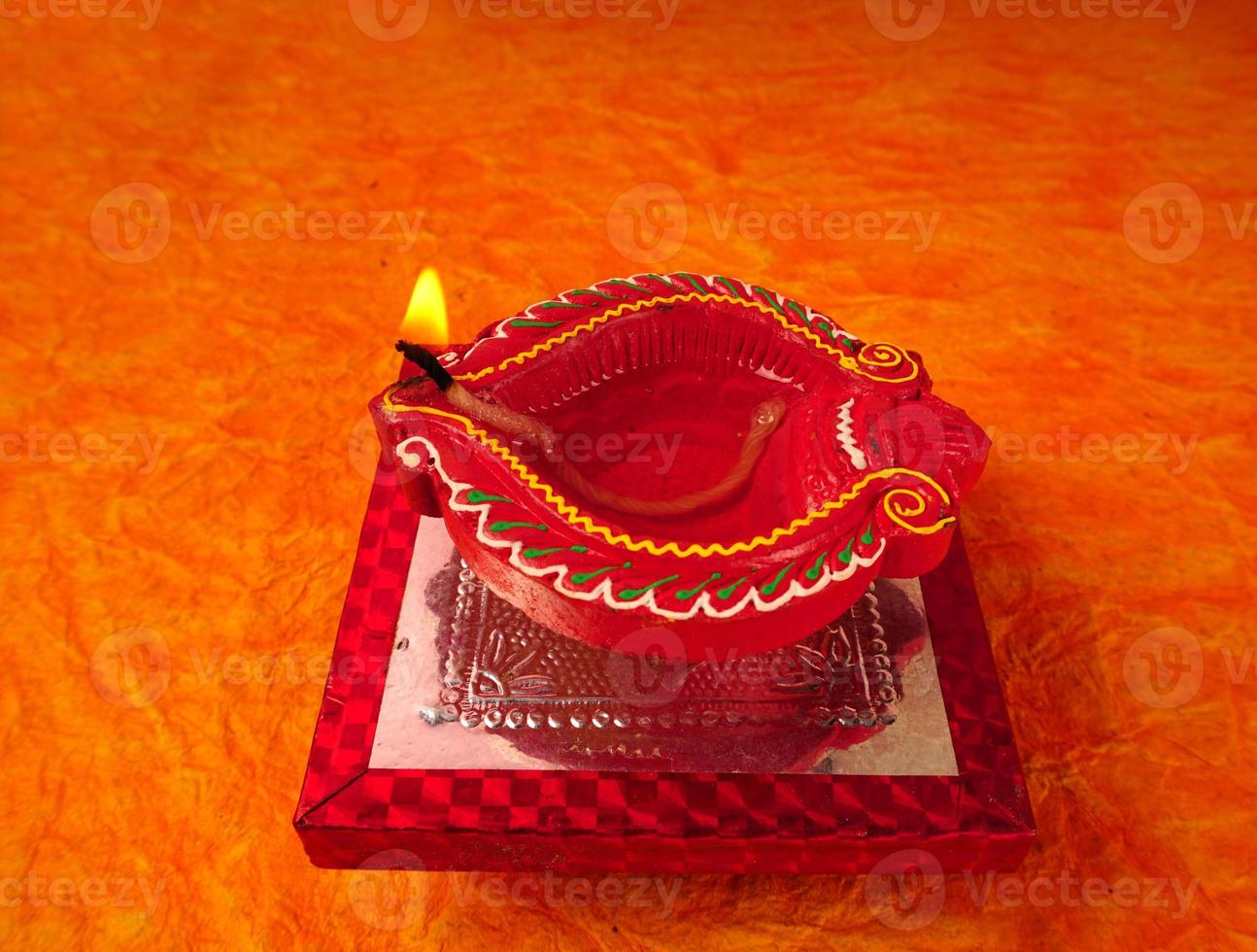 Happy Diwali - Diya lamps lit during Diwali celebration. Colourful and decorated lantern are lit in night on this occassion with flower rangoli, sweets and gifts. photo