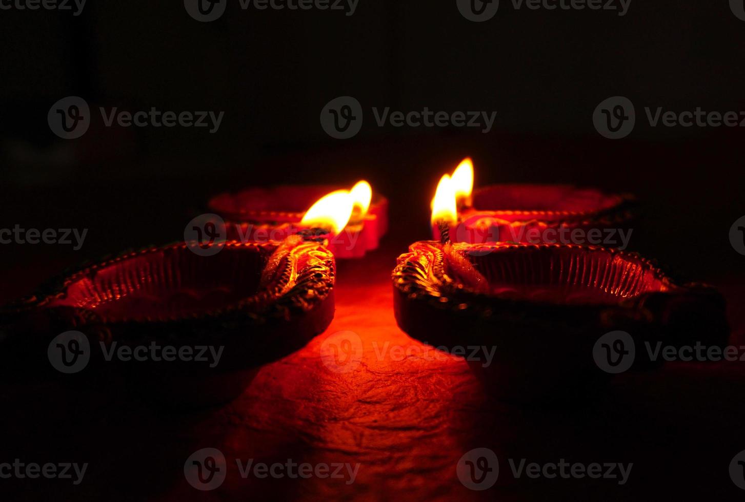 Happy Diwali - Diya lamps lit during Diwali celebration. Colourful and decorated lantern are lit in night on this occassion with flower rangoli, sweets and gifts. photo