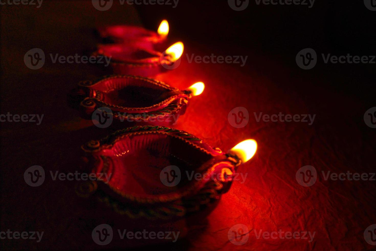 Happy Diwali - Diya lamps lit during Diwali celebration. Colourful and decorated lantern are lit in night on this occassion with flower rangoli, sweets and gifts. photo