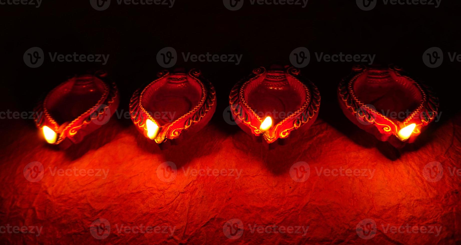 Happy Diwali - Diya lamps lit during Diwali celebration. Colourful and decorated lantern are lit in night on this occassion with flower rangoli, sweets and gifts. photo