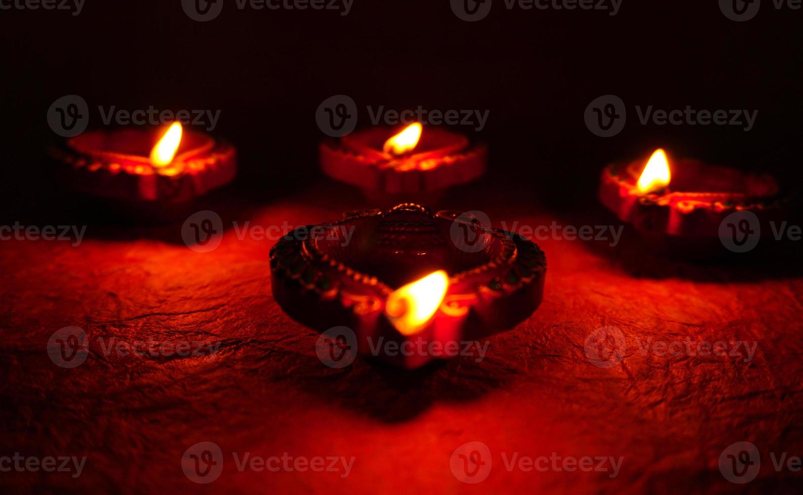 Happy Diwali - Diya lamps lit during Diwali celebration. Colourful and decorated lantern are lit in night on this occassion with flower rangoli, sweets and gifts. photo