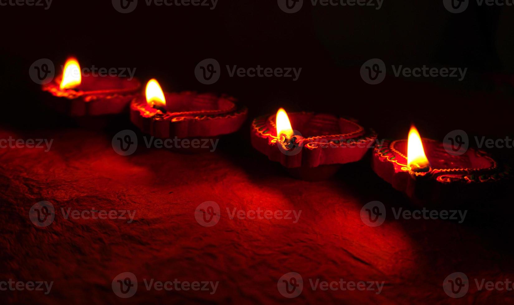 Happy Diwali - Diya lamps lit during Diwali celebration. Colourful and decorated lantern are lit in night on this occassion with flower rangoli, sweets and gifts. photo