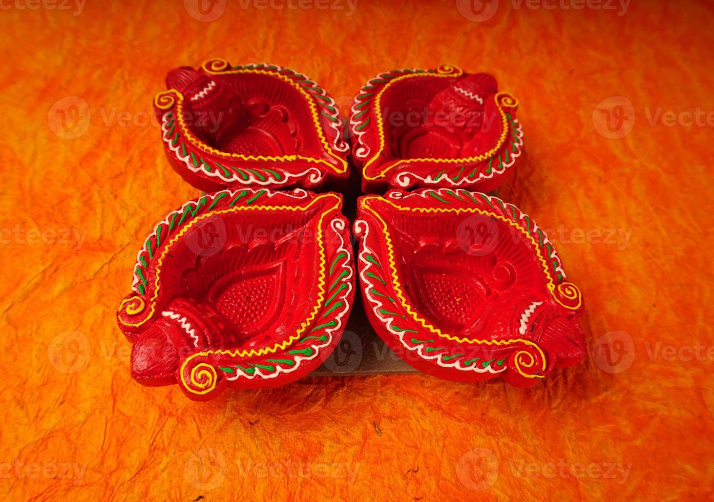 Happy Diwali - Diya lamps lit during Diwali celebration. Colourful and decorated lantern are lit in night on this occassion with flower rangoli, sweets and gifts. photo