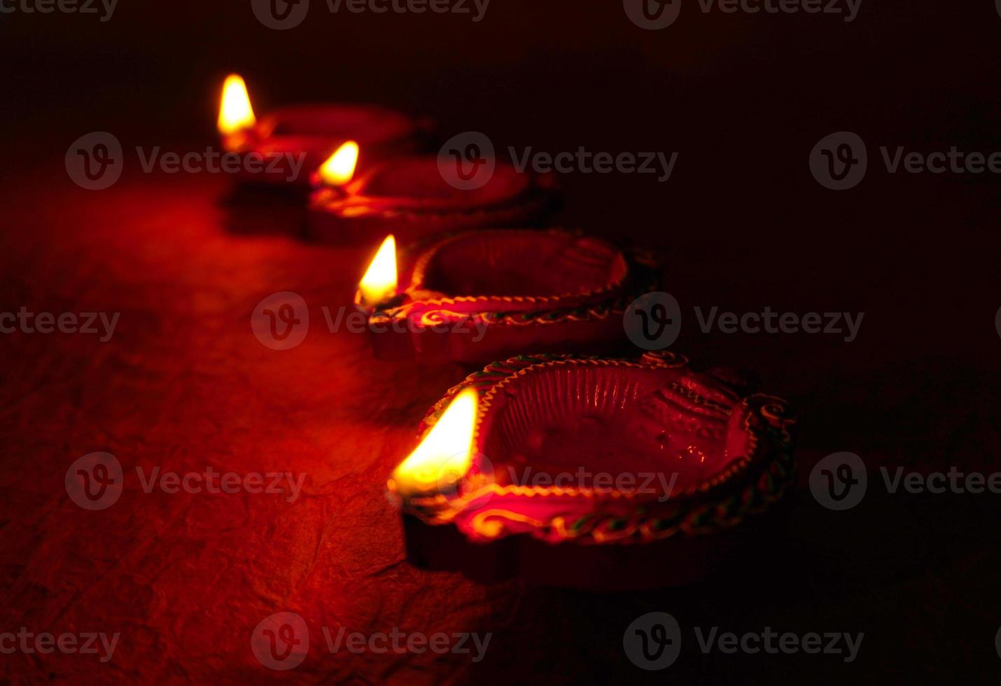 Happy Diwali - Diya lamps lit during Diwali celebration. Colourful and decorated lantern are lit in night on this occassion with flower rangoli, sweets and gifts. photo