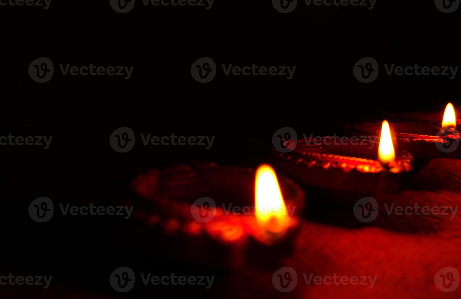 Happy Diwali - Diya lamps lit during Diwali celebration. Colourful and decorated lantern are lit in night on this occassion with flower rangoli, sweets and gifts. photo