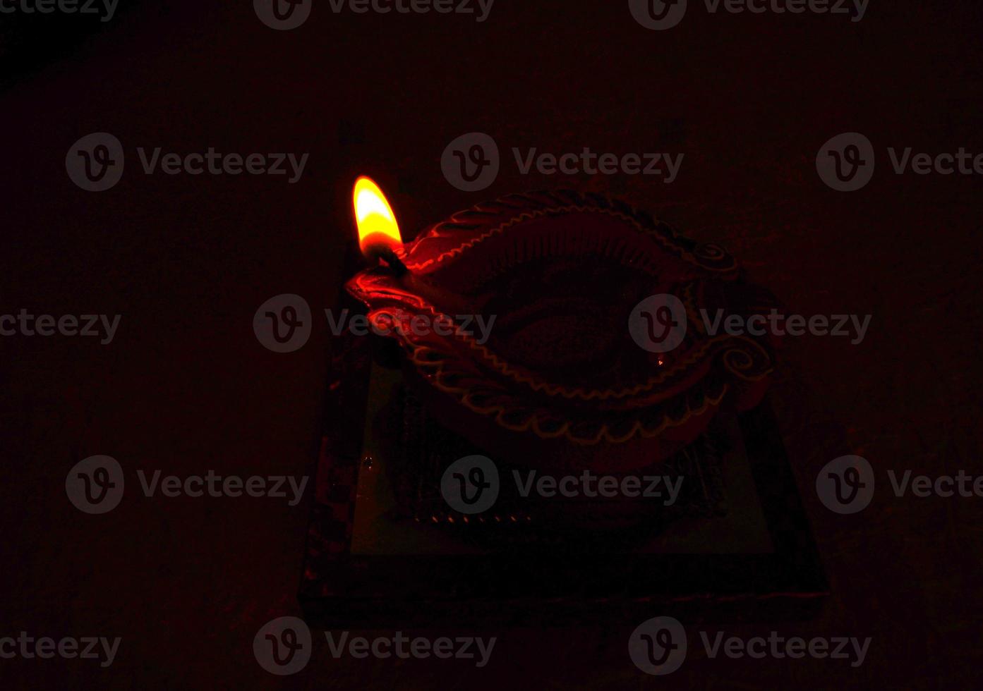 Happy Diwali - Diya lamps lit during Diwali celebration. Colourful and decorated lantern are lit in night on this occassion with flower rangoli, sweets and gifts. photo