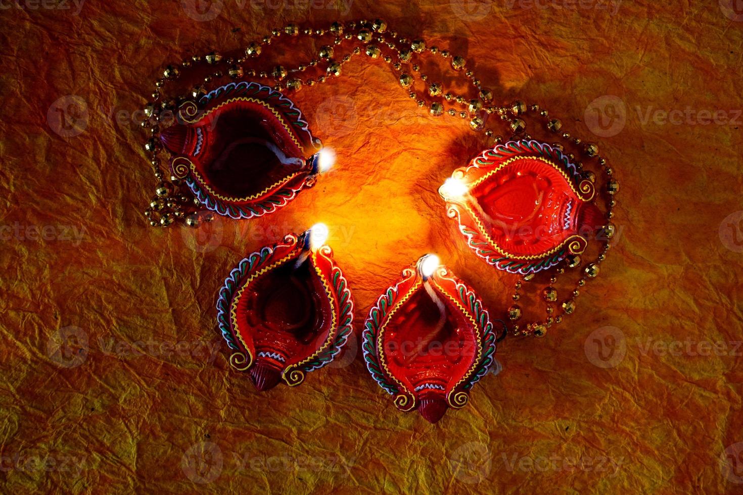 Happy Diwali - Diya lamps lit during Diwali celebration. Colourful and decorated lantern are lit in night on this occassion with flower rangoli, sweets and gifts. photo
