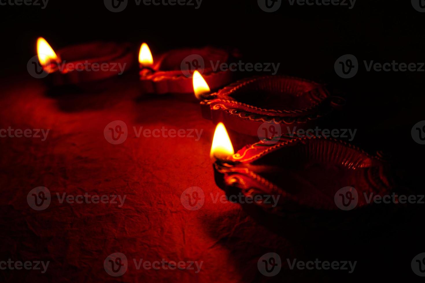 Happy Diwali - Diya lamps lit during Diwali celebration. Colourful and decorated lantern are lit in night on this occassion with flower rangoli, sweets and gifts. photo