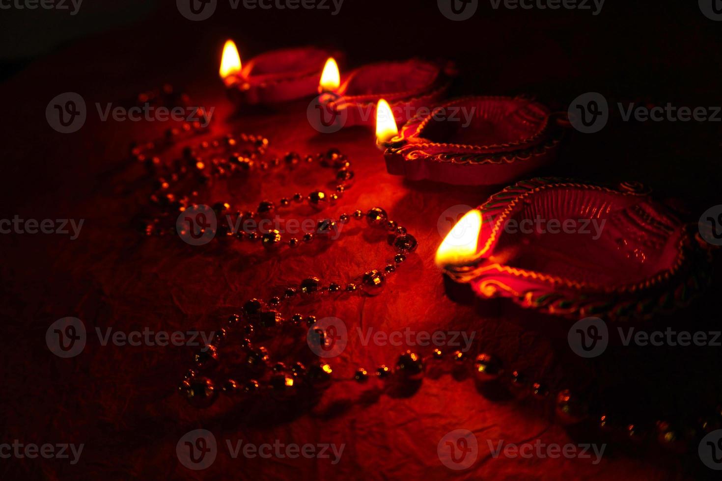 Happy Diwali - Diya lamps lit during Diwali celebration. Colourful and decorated lantern are lit in night on this occassion with flower rangoli, sweets and gifts. photo