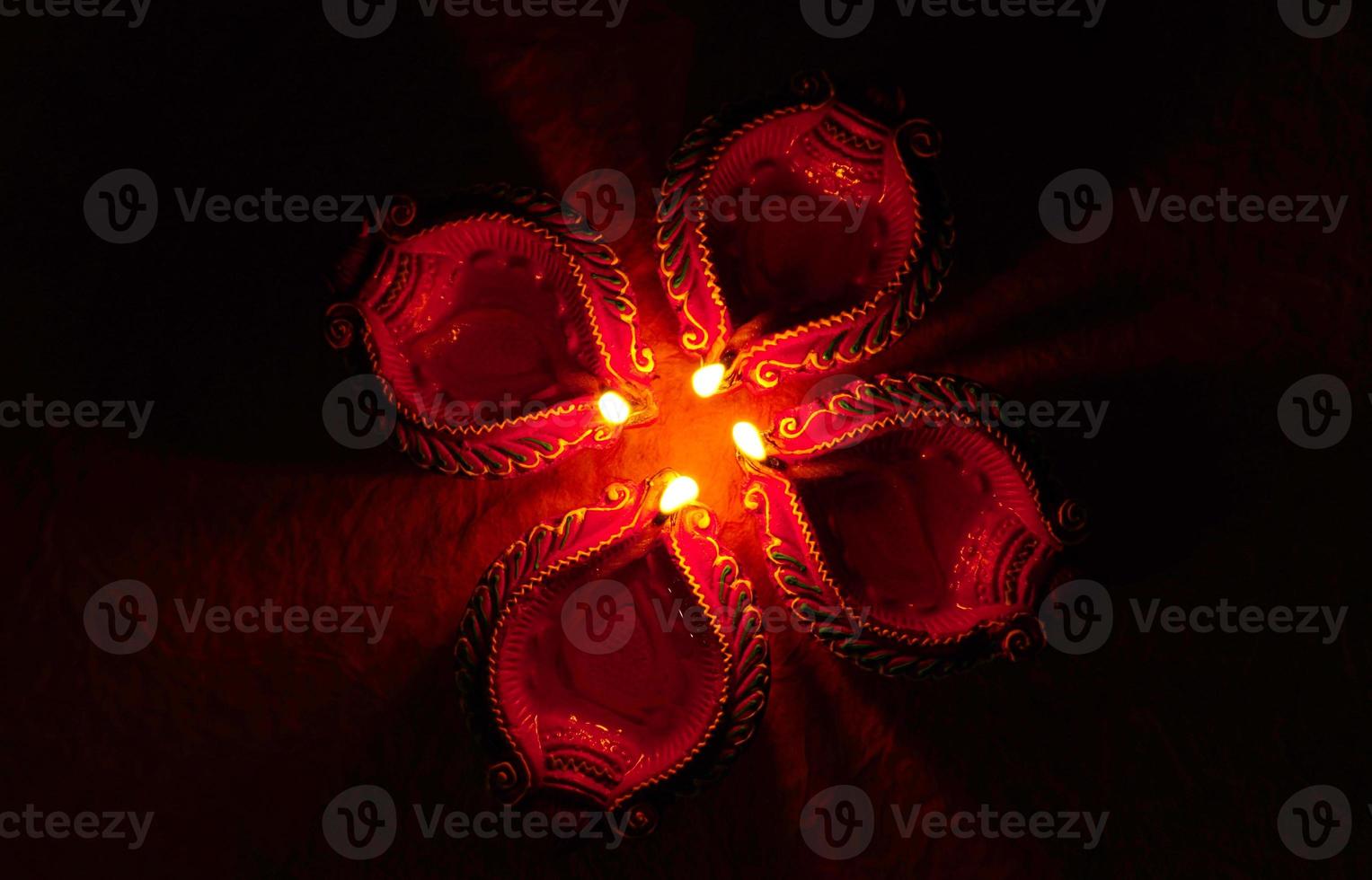 Happy Diwali - Diya lamps lit during Diwali celebration. Colourful and decorated lantern are lit in night on this occassion with flower rangoli, sweets and gifts. photo