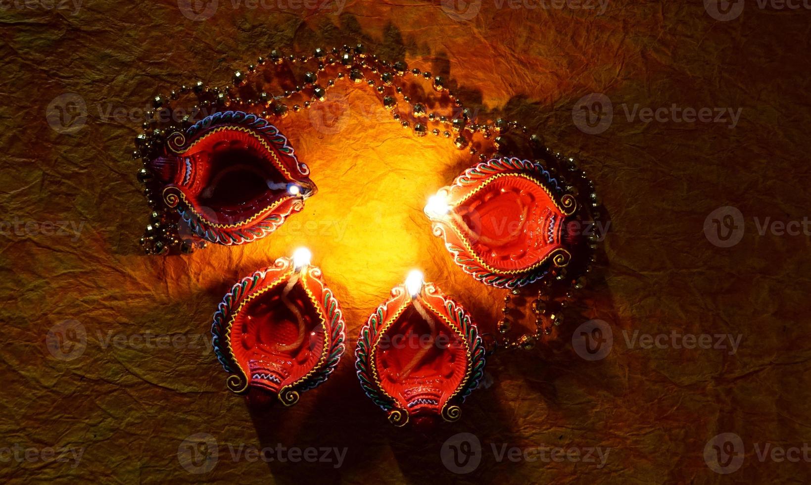 Happy Diwali - Diya lamps lit during Diwali celebration. Colourful and decorated lantern are lit in night on this occassion with flower rangoli, sweets and gifts. photo