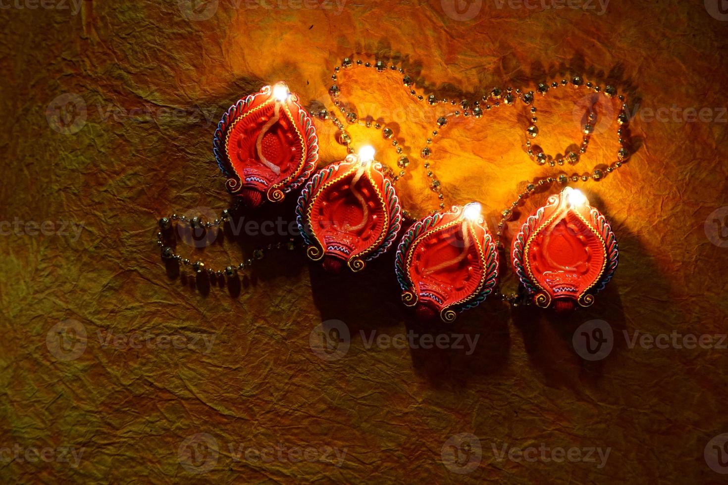 Happy Diwali - Diya lamps lit during Diwali celebration. Colourful and decorated lantern are lit in night on this occassion with flower rangoli, sweets and gifts. photo